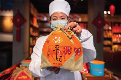 在位于山西省晉中市平遙縣的平遙古城南大街的一家平遙牛肉店內，工作人員展示一款牛肉產品（資料照片）楊晨光攝 / 本刊