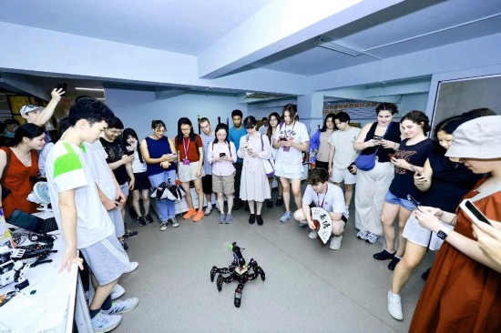 8月25日，中外青年在浙江杭州觀看機器人表演。新華社發(fā)（清華大學供圖）