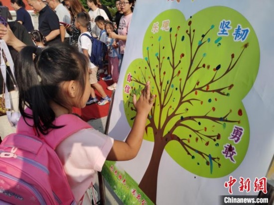 圖為衡水市利民路小學(xué)，孩子們?cè)诔砷L樹的“好習(xí)慣”樹枝上按手印做出承諾。張松 攝