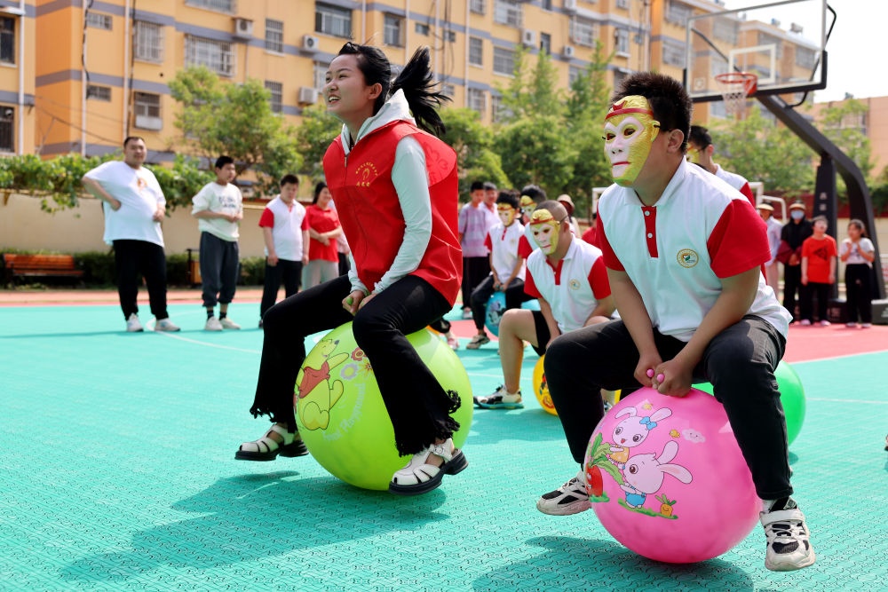 2024年5月17日，在山東省棗莊市市中區(qū)特殊教育中心，青年志愿者與智力障礙學(xué)生一起做游戲。新華社發(fā)（孫中喆攝）