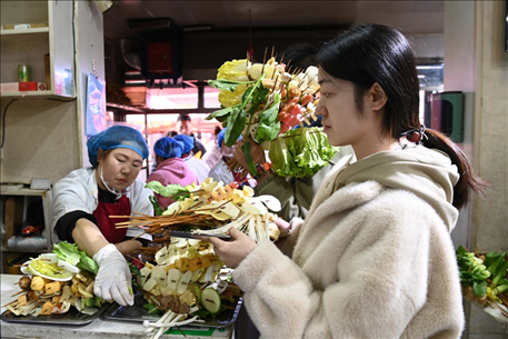 游客挑選好麻辣燙菜品后排隊(duì)等待加工。新華社記者 范培珅 攝