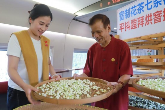 10月1日，福州市茉莉花茶窨制工藝代表性傳承人張子建與旅客在G1634次列車上制作茉莉花茶。新華社記者周義 攝