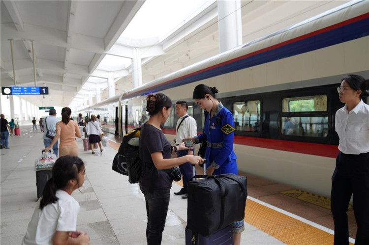 中老鐵路工作人員在站臺指引旅客進站乘車。老中鐵路有限公司供圖