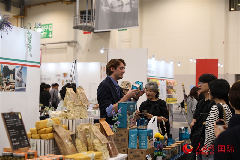當(dāng)?shù)貢r(shí)間10月5日，在第21屆釜山國(guó)際美食博覽會(huì)上，意大利展商向參觀者們介紹的意大利食品。人民網(wǎng)記者 莽九晨攝