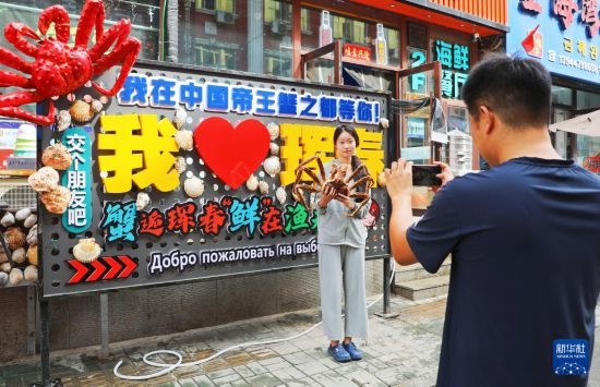 9月21日，游客在吉林省琿春市一處帝王蟹元素主題裝飾前拍照留念。新華社發(fā)