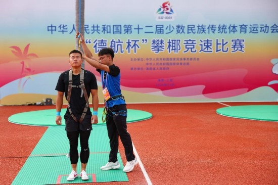 11月23日，工作人員為上海隊(duì)選手付樂樂（左）系安全繩。新華社記者 楊植森 攝