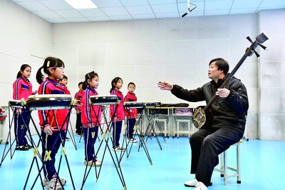 圖為12月30日，在惠民縣胡集鎮(zhèn)第一小學(xué)，老師指導(dǎo)學(xué)生學(xué)習(xí)西河大鼓。新華社記者 郭緒雷攝