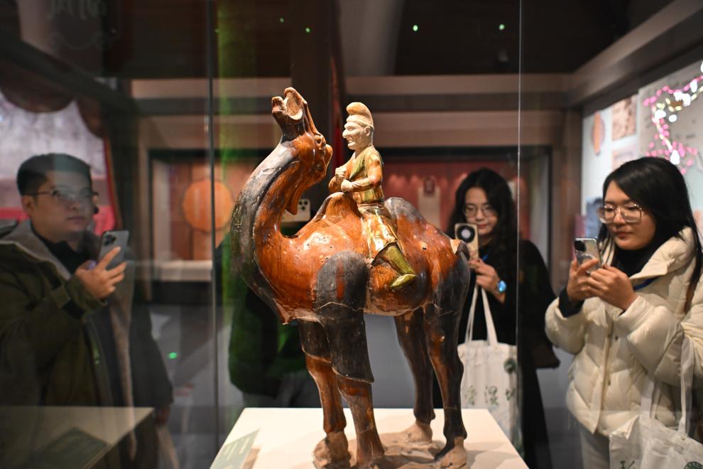 1月15日，觀眾在拍攝“長安三萬里——陜西唐代文物精華展”展出的三彩胡人騎駝俑。（新華社記者 孫凡越 攝）