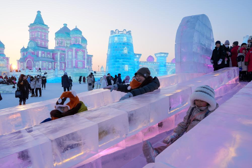 游客在哈爾濱冰雪大世界園區(qū)內(nèi)體驗冰滑梯。新華社發(fā)