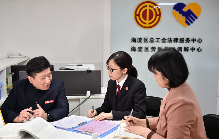 2025年3月6日，在北京市海淀區(qū)總工會勞動爭議調(diào)解中心，海淀區(qū)人民法院法官王琰（中）與該中心工作人員就糾紛化解情況進(jìn)行溝通。新華社記者 趙婷婷 攝