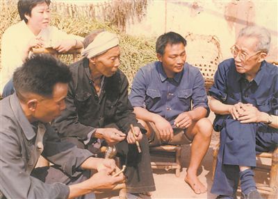 侯光炯（右一）和農(nóng)民在一起親切交流。 西南大學(xué)檔案館供圖